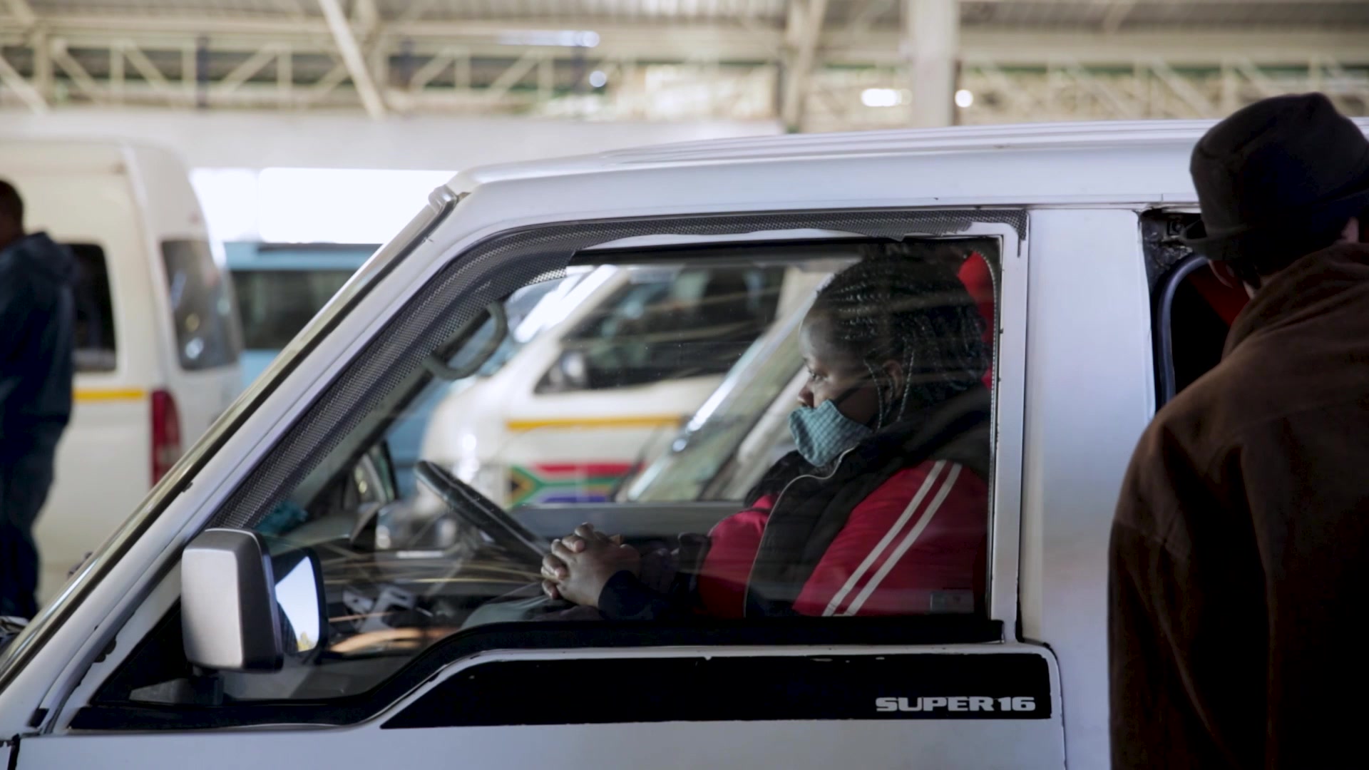 Passengers getting into a taxi wearing face masks