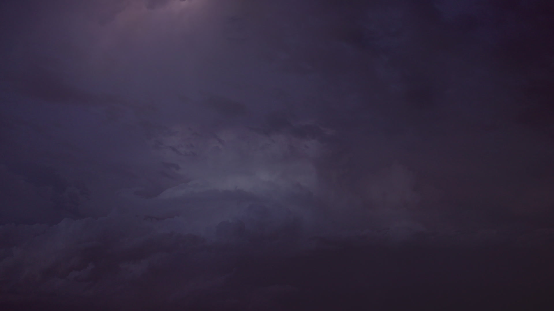 Lightning illuminates spinning supercell, dusk