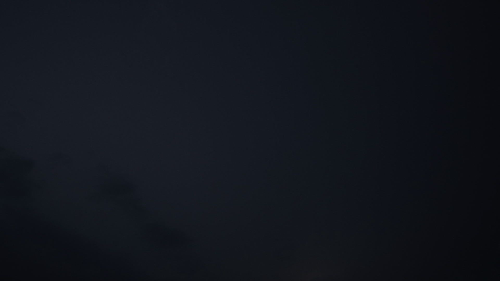 Hooked lightning flashes above clouds, night