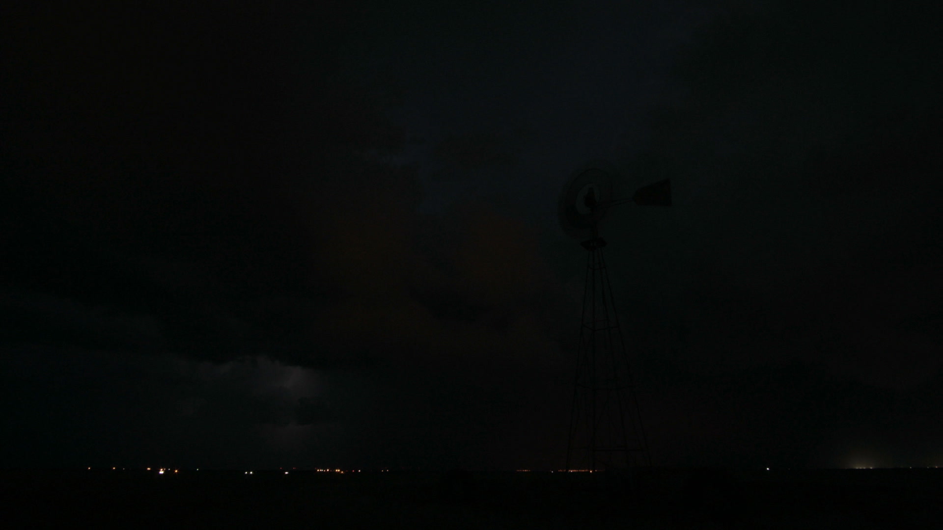 Lightning behind windmill, night, wide shot