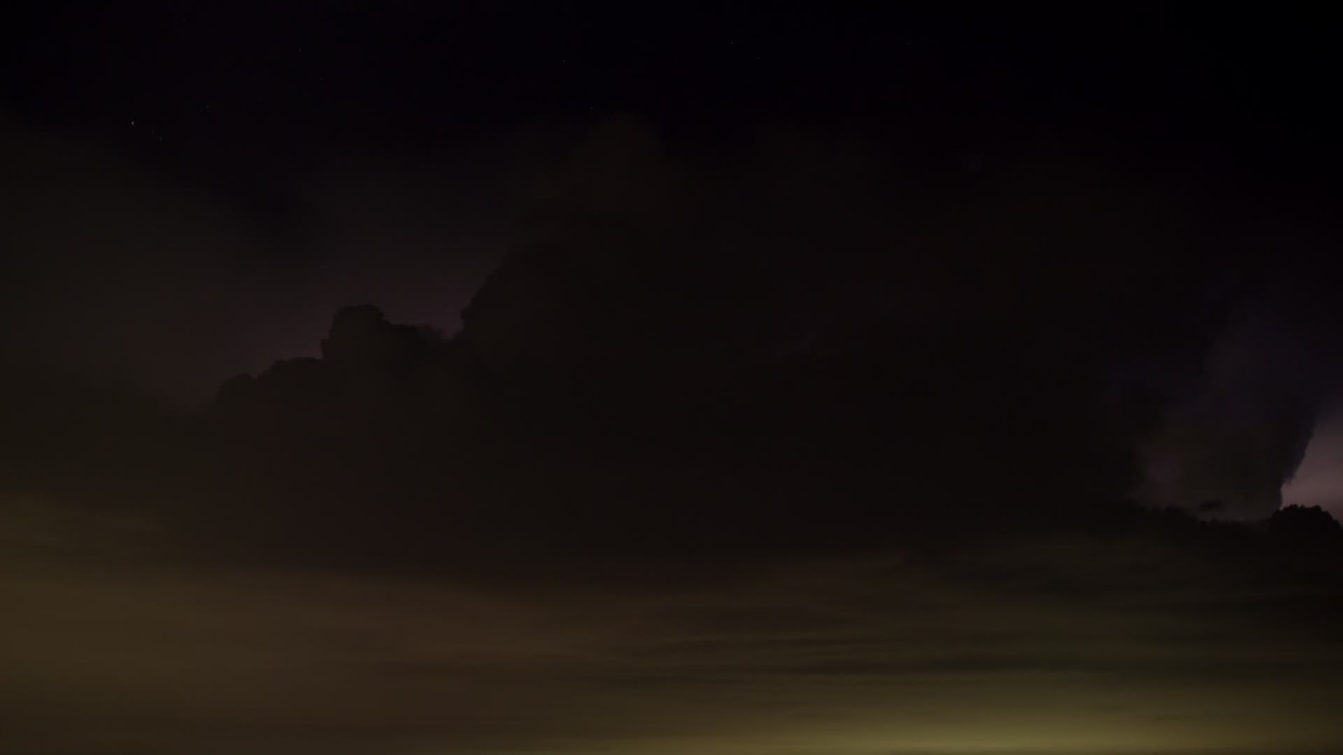 Continuous flashes of lightning fill storm above city, night