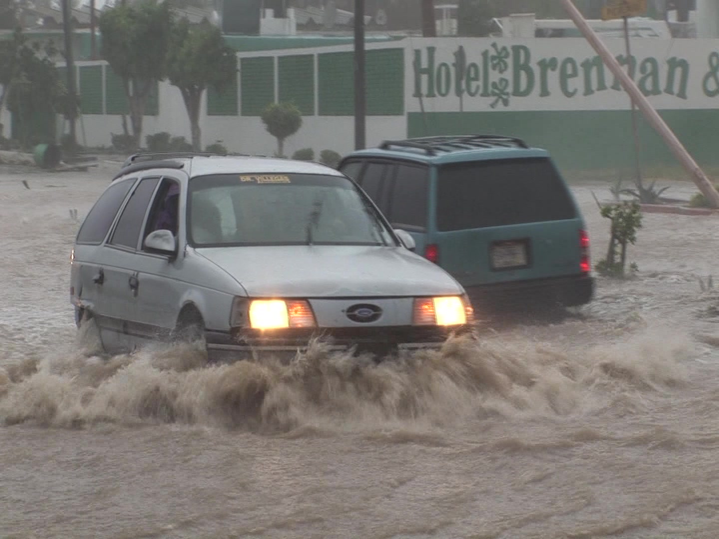 Cars drive through flooded road during hurricane