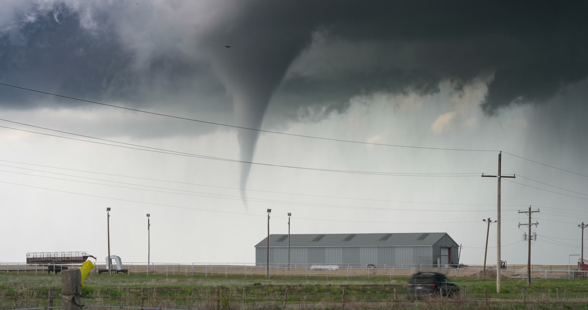 Texas Twister! Classic tornado passes behind farm as storm chaser drives by, South Plains, Texas, 4K