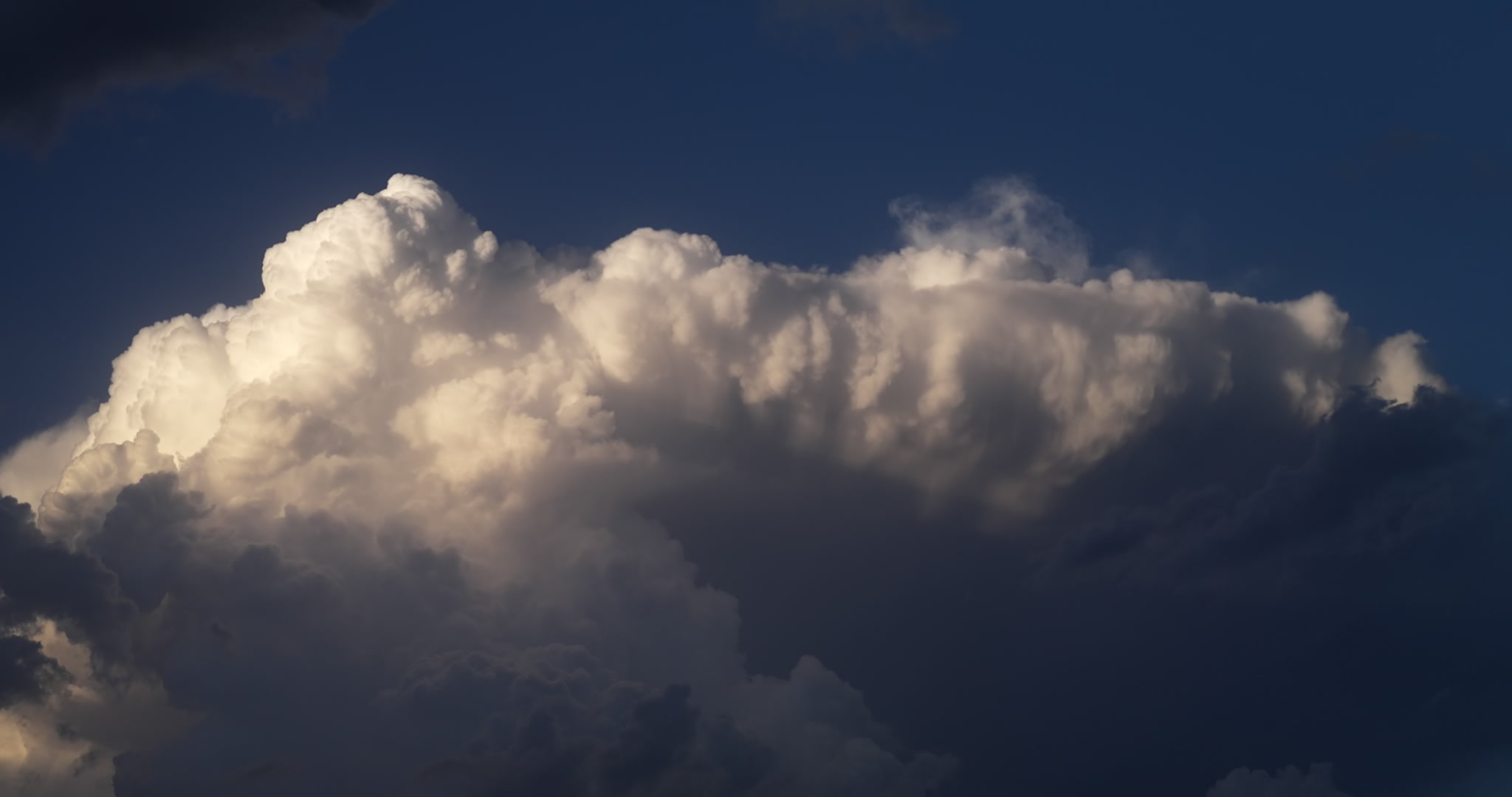 4K Storm Clouds - Tall thunderstorm lit by setting sun