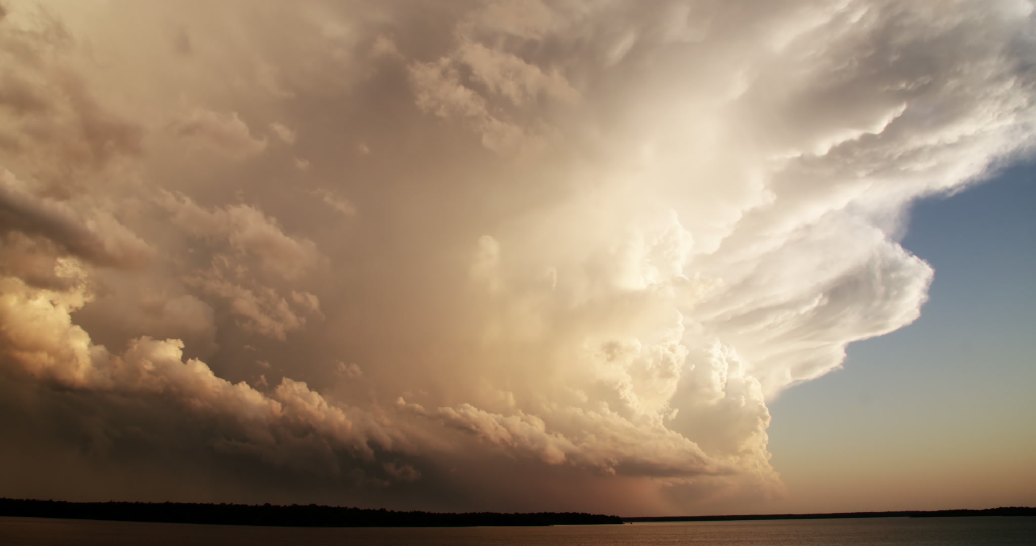 Storm clouds - Large, golden thunderstorm over lake, late day, time-lapse, 4K