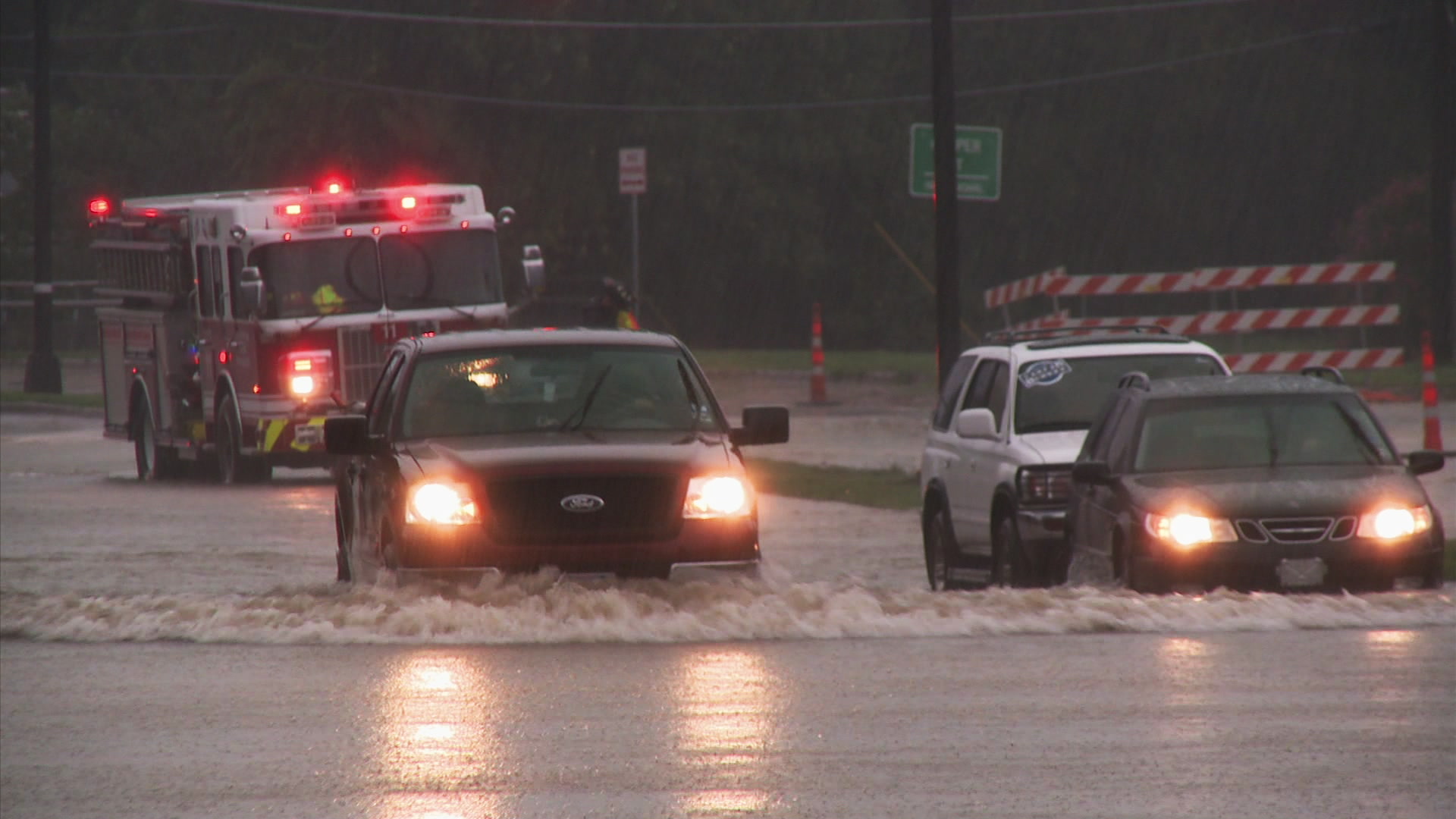 Urban flooding - cars trying to drive through flood water, fire truck, HD