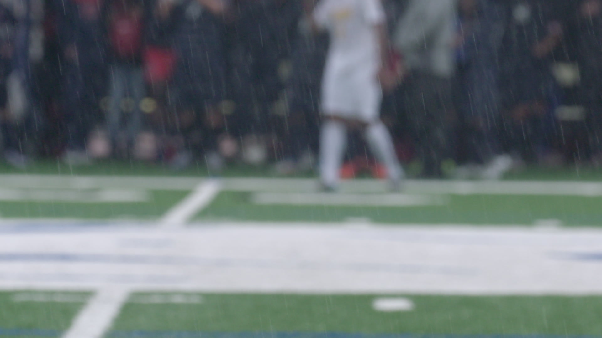 Rain falls during soccer game, slow-motion, close-up, 4K
