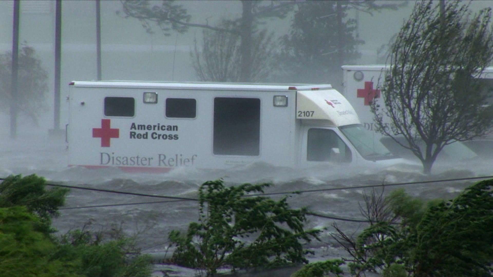 Dramatic shot of Red Cross Disaster Relief truck caught in storm surge, high winds, Hurricane Katrina, 4K