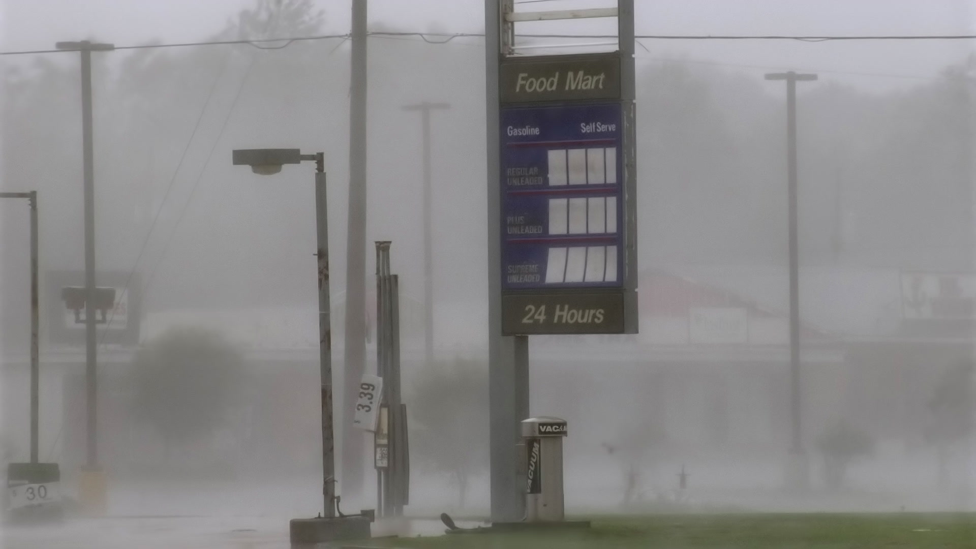 Intense wind and rain blow past food mart sign, Hurricane Katrina, Super 35mm film to 4K