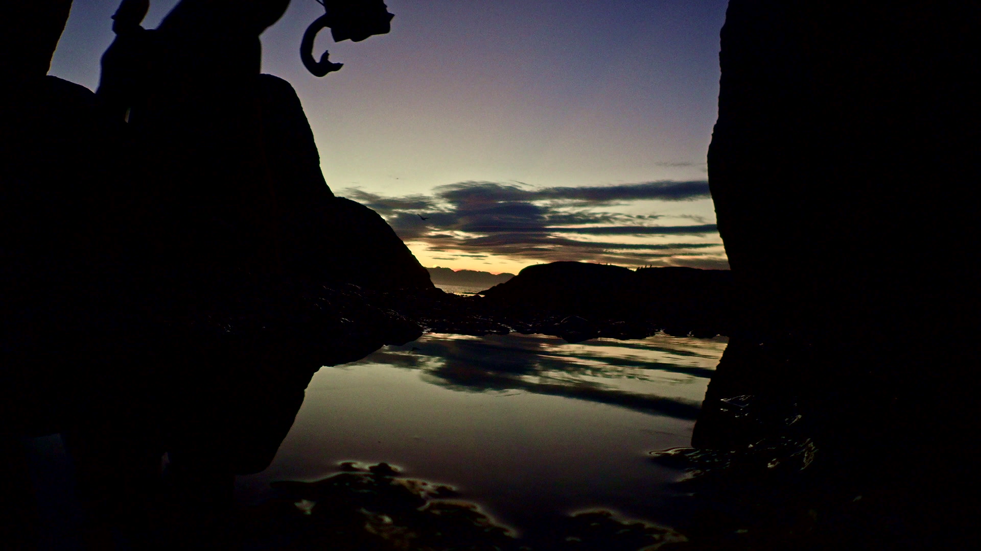 Silhouette of a snorkeler coming out of the ocean at dusk