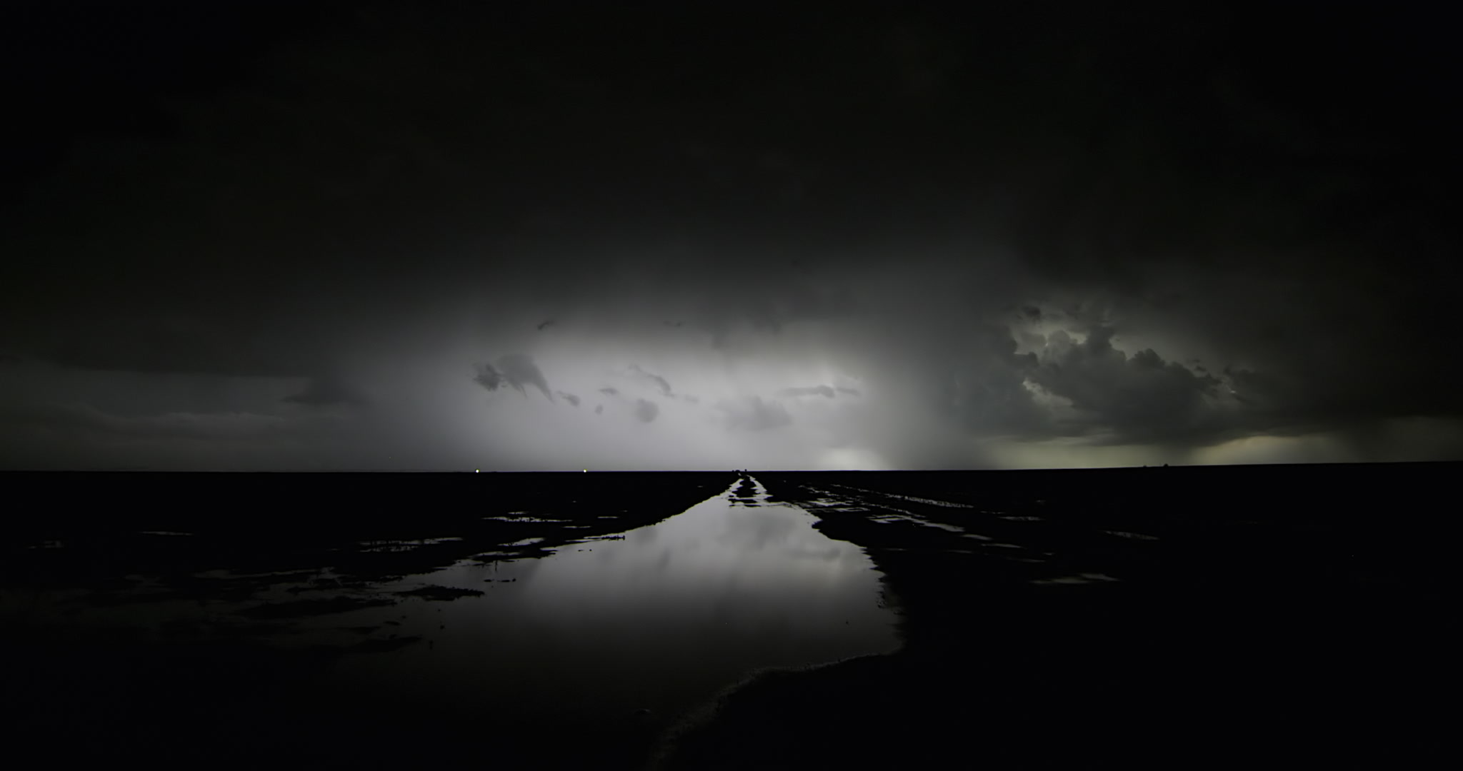 Beautiful, dramatic shot of continuous lightning storm over flooded farm road, Kansas, 4K