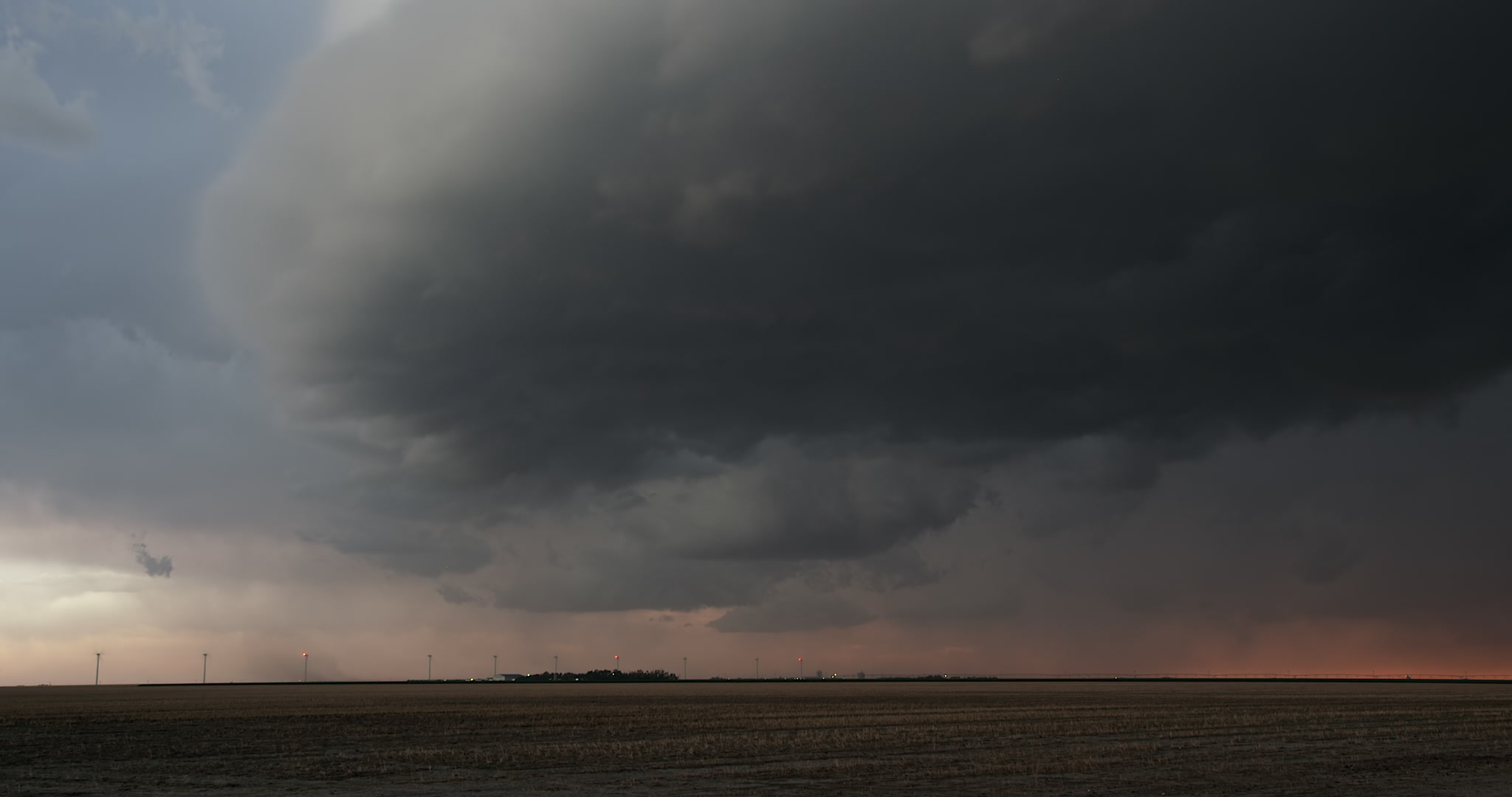 Severe thunderstorm approaches over flat farm country, evening, 4K