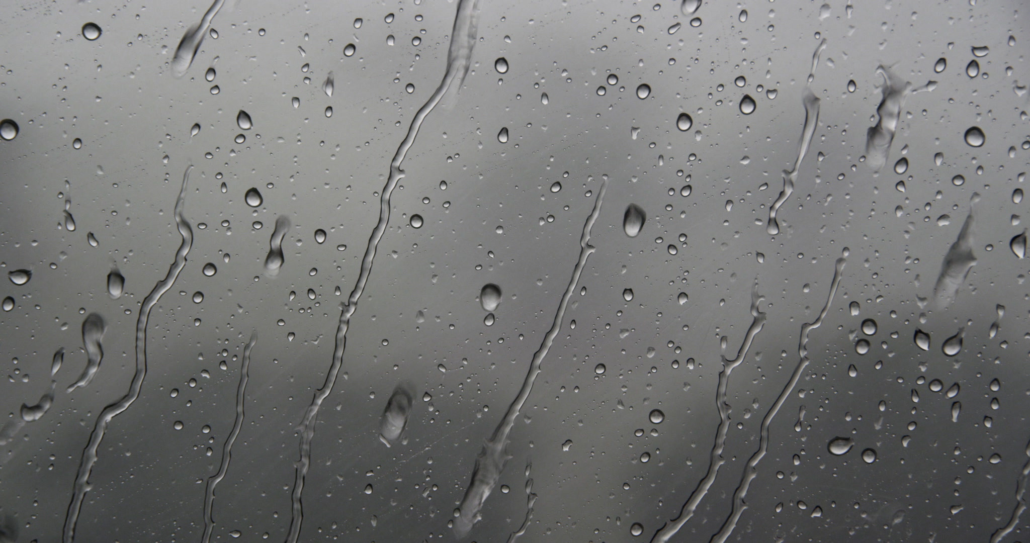 Close-up of rain flowing down window, day, 4K