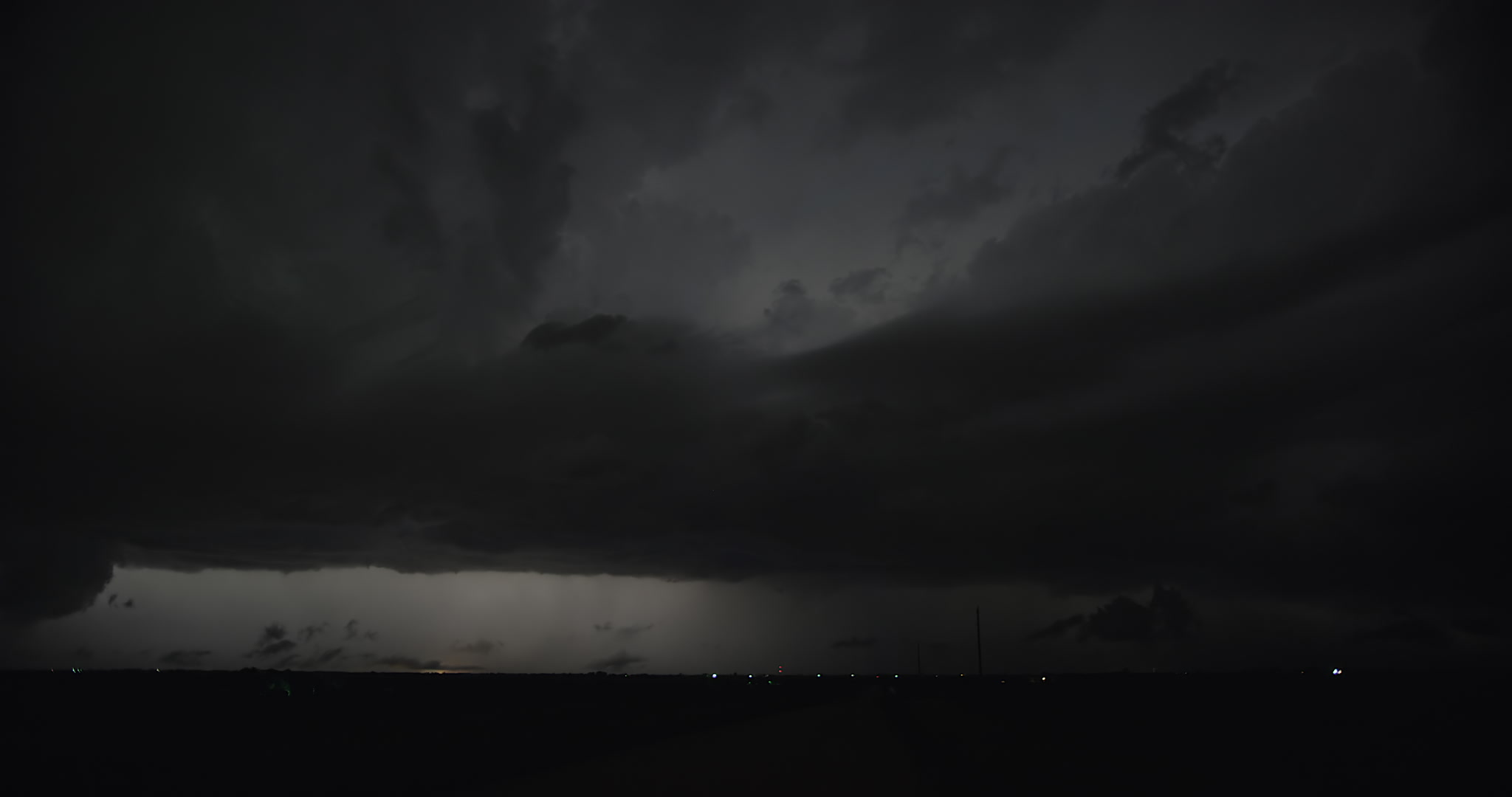 Continuous lightning flashes over rural road,  two storms, night, Nebraska, 4K