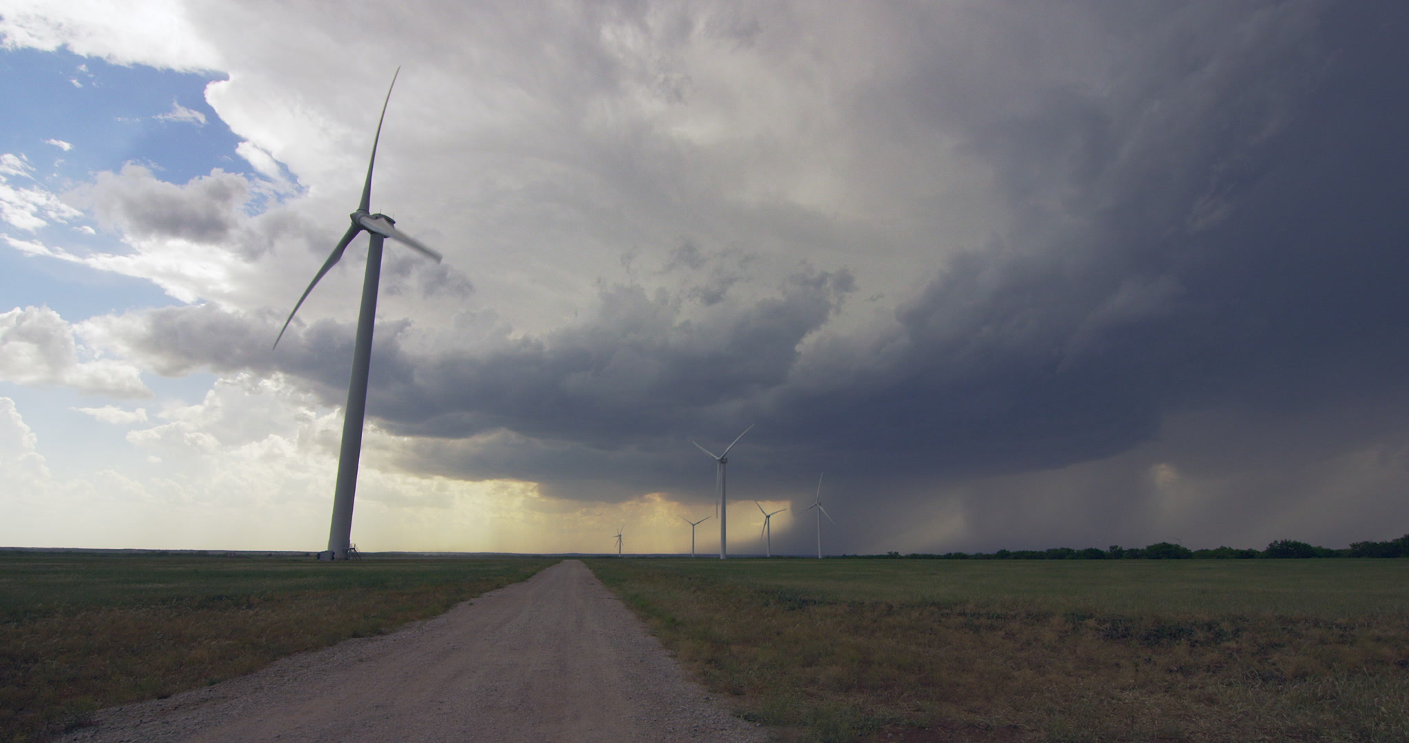 Severe thunderstorm approaches over wind farm, late afternoon, Texas, 4K