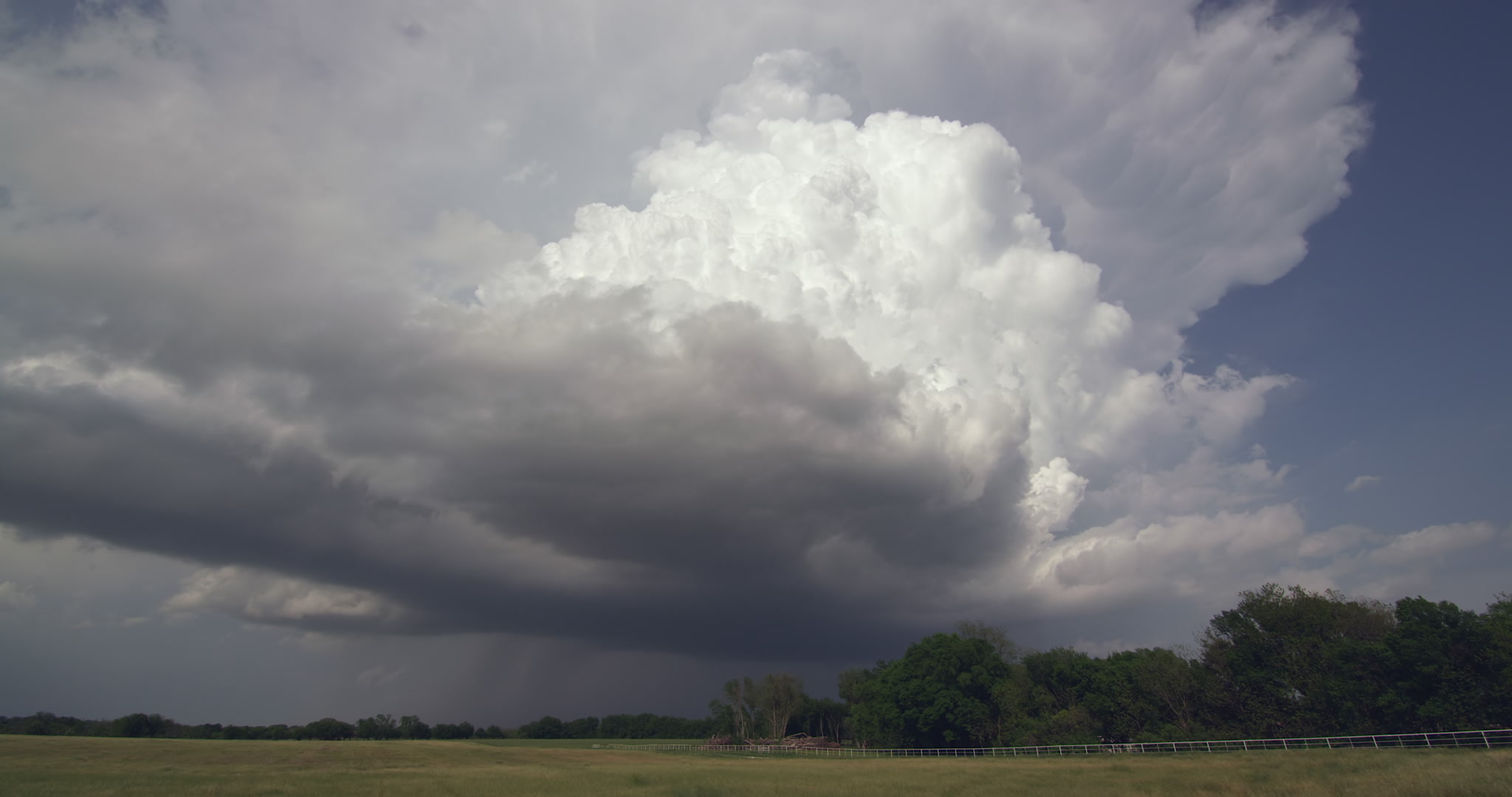 Large thunderstorm develops, billows upward over farm, late afternoon, 4K