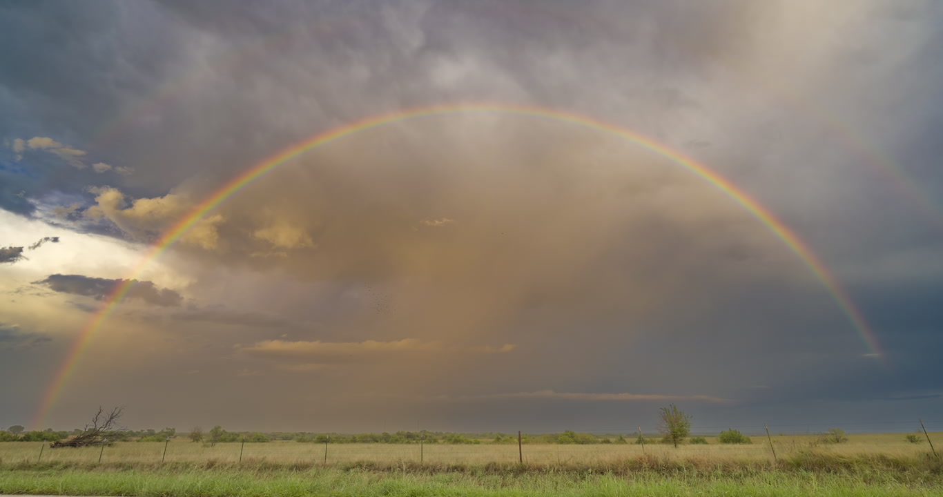 Full rainbow over green prairie, real-time, 4K
