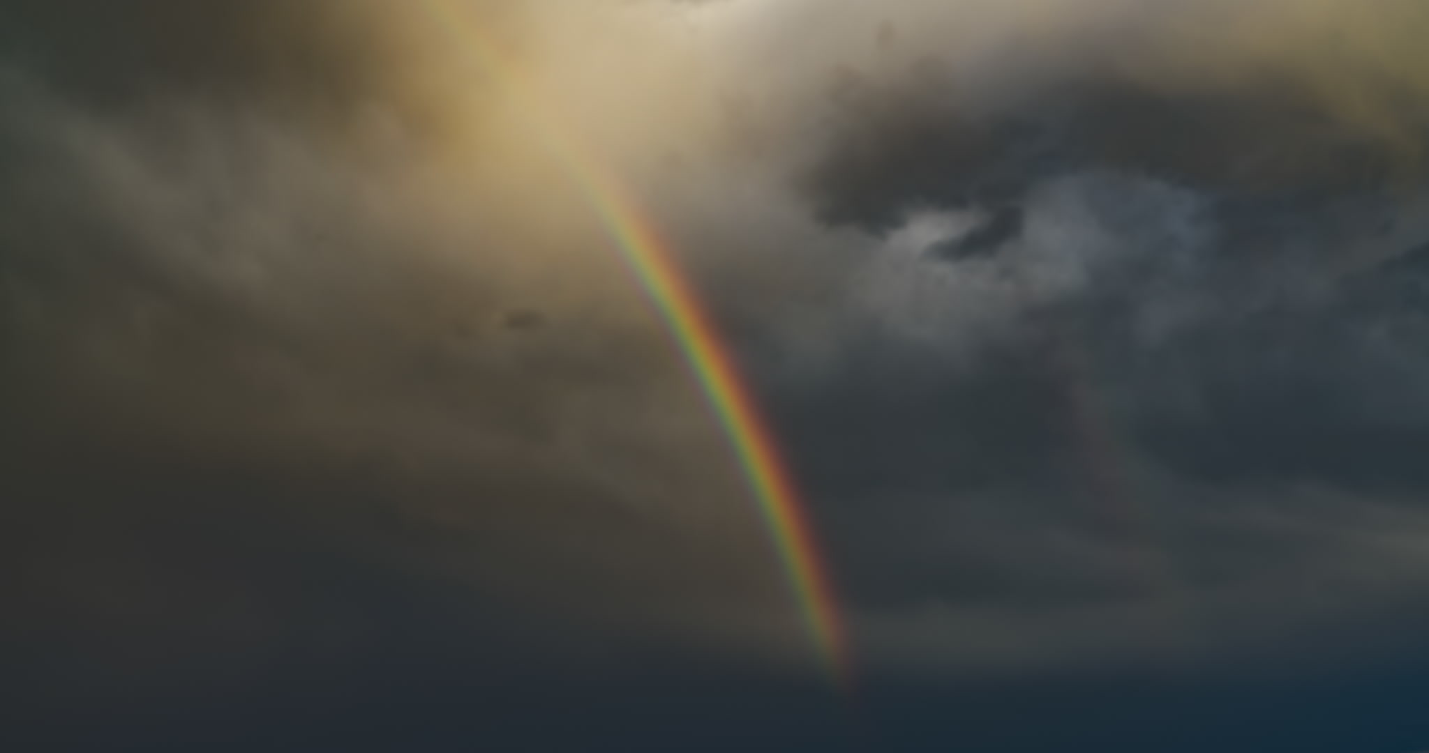Rainbow segment against dark, stormy sky, close-up, time-lapse, 4K