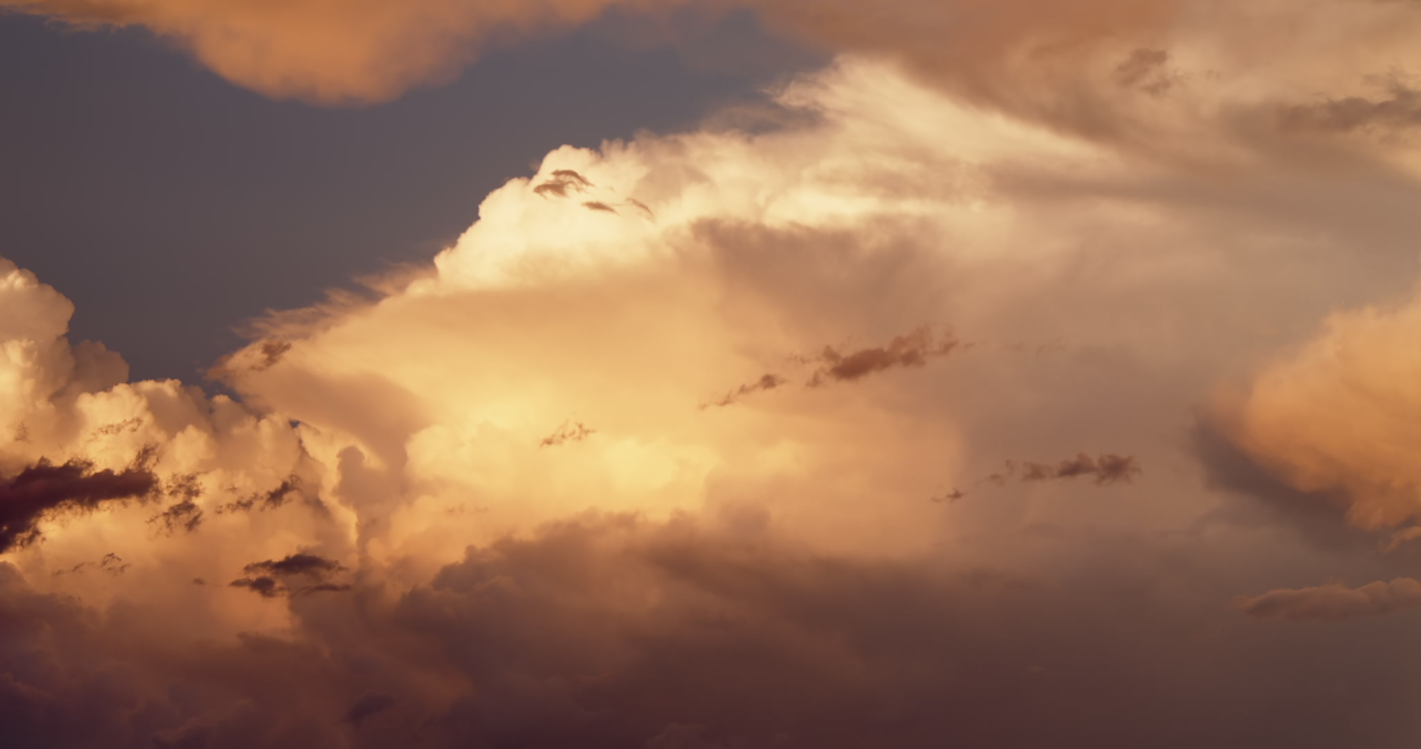 Tall, severe storm lit orange by setting sun, 4K
