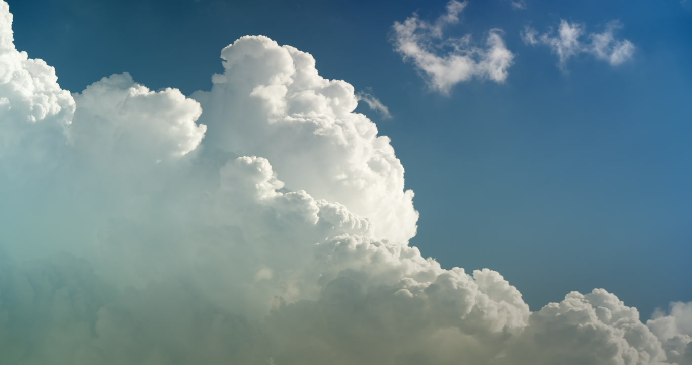 Tall, towering cumulus cloud builds upward into blue sky, 4K