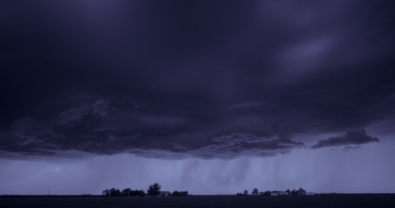 Huge severe storm spins over two farms at night, real-time, long-duration shot, lightning flash, 4K