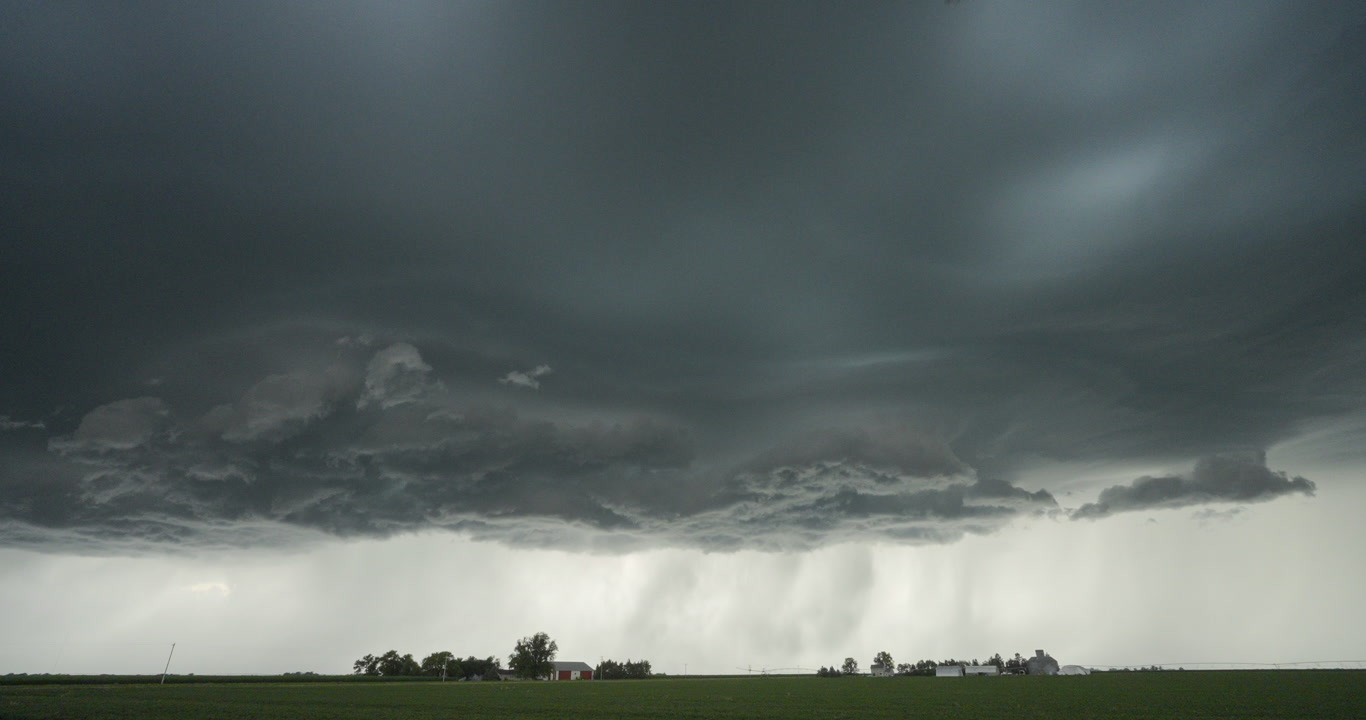 Long-duration, real-time shot of severe storm passing over two farms, 4K