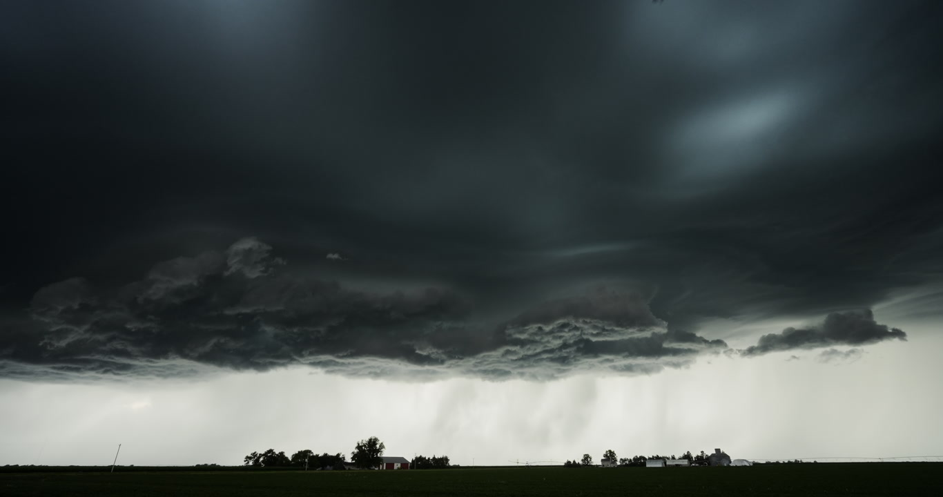 Real-time shot, alien like storm with lightning bolt passes over two farms