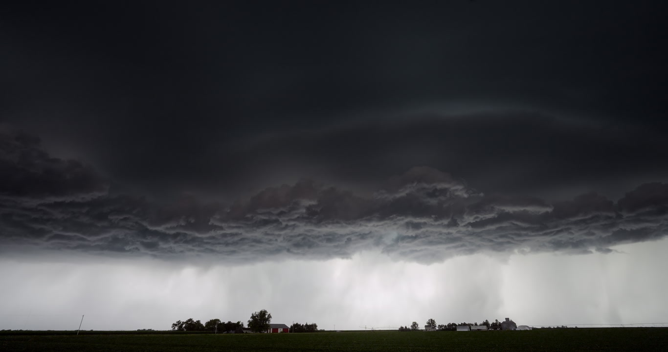 Time-lapse, big, spinning supercell over two farms, 4K