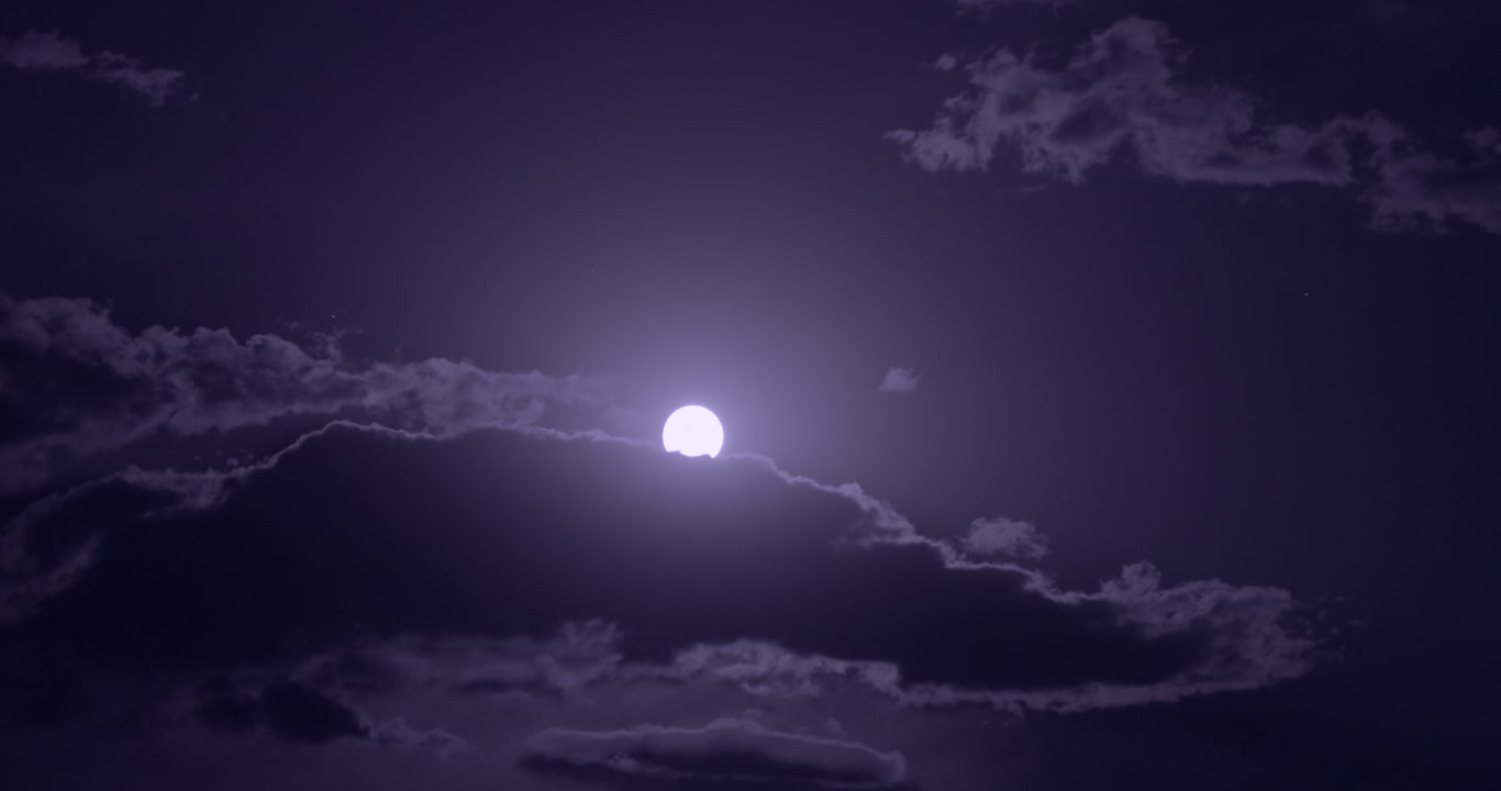 Full moon appears from behind clouds, bright, blue sky at night, 4K