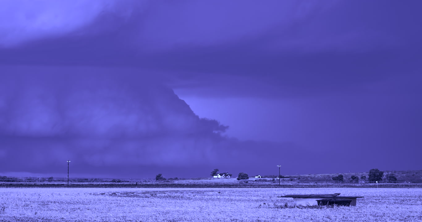 Intense supercell thunderstorm with large lightning bolt strikes approaches farm at night, Texas, 4K