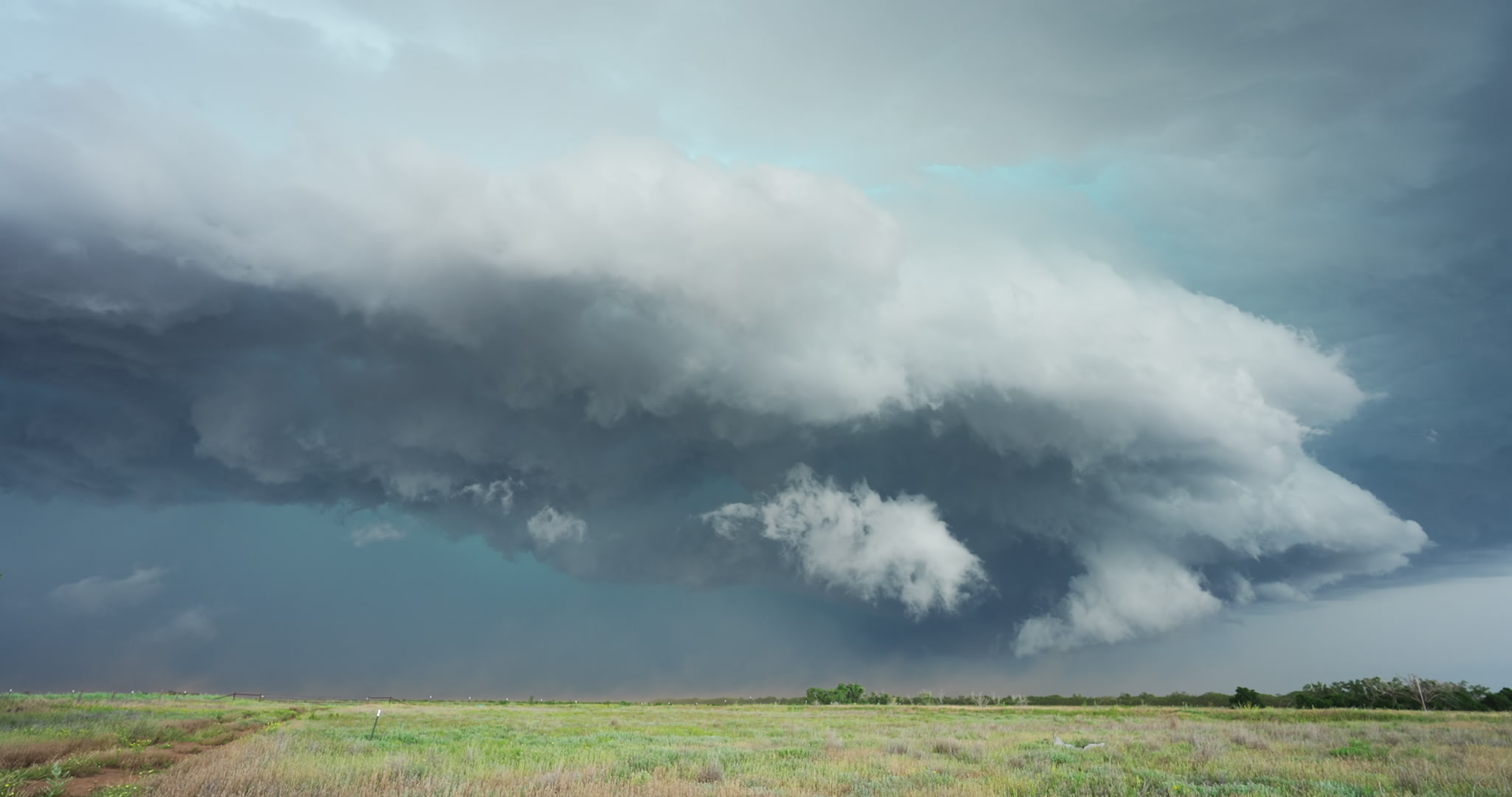 Large thunderstorm with shelf cloud and blowing dust drifts across Texas prairie, 4K
