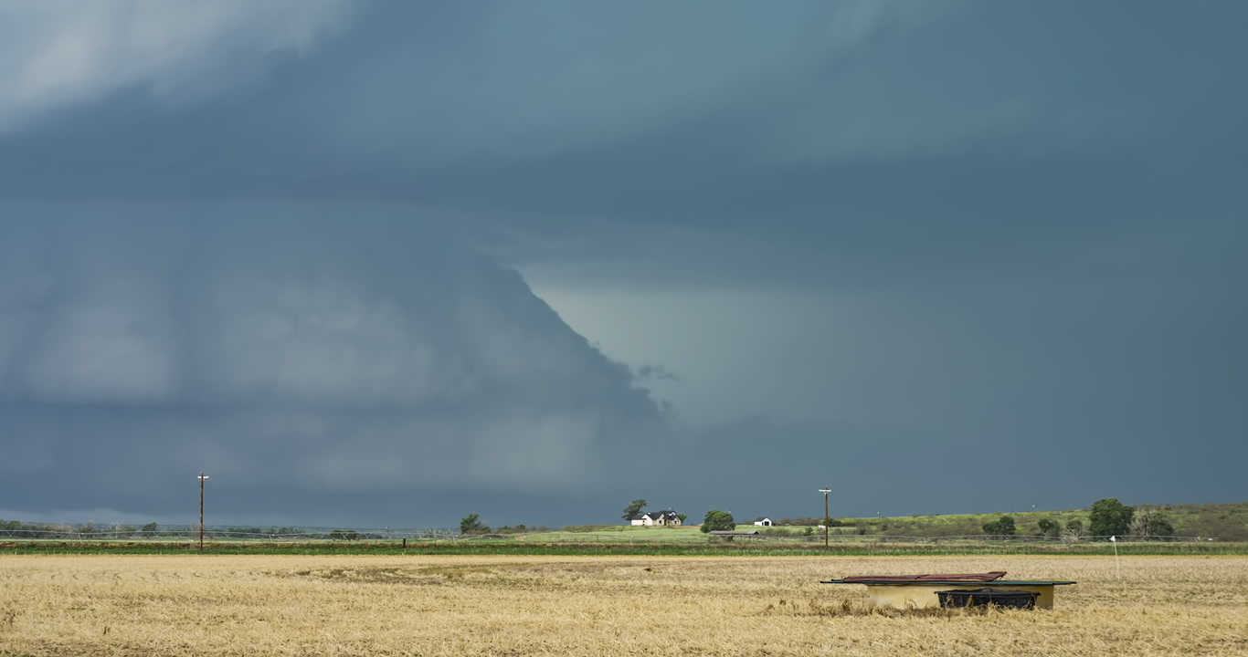 Large supercell thunderstorm with big bolts of lightning approaches Texas farm, 4K