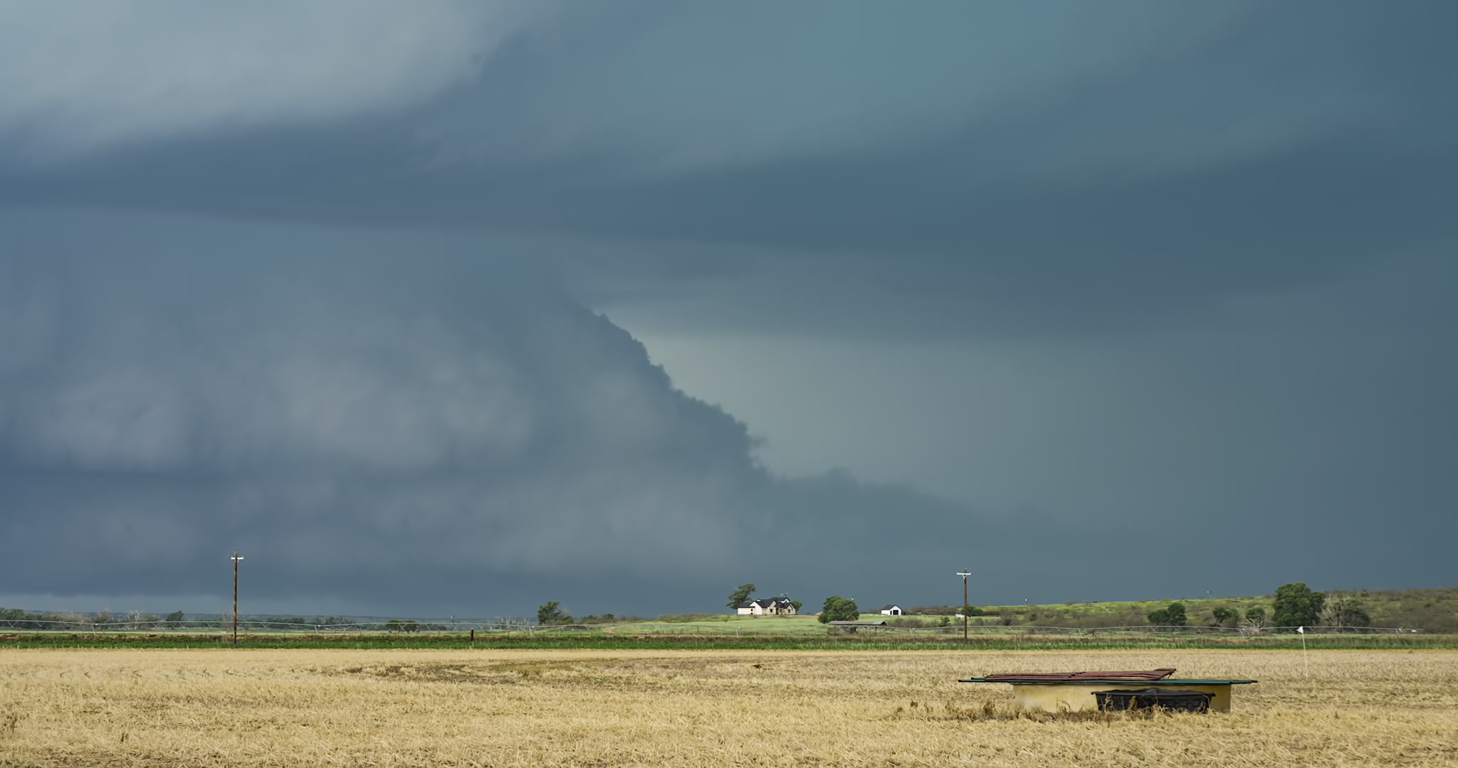 Large supercell thunderstorm with big bolts of lightning approaches Texas farm, 4K