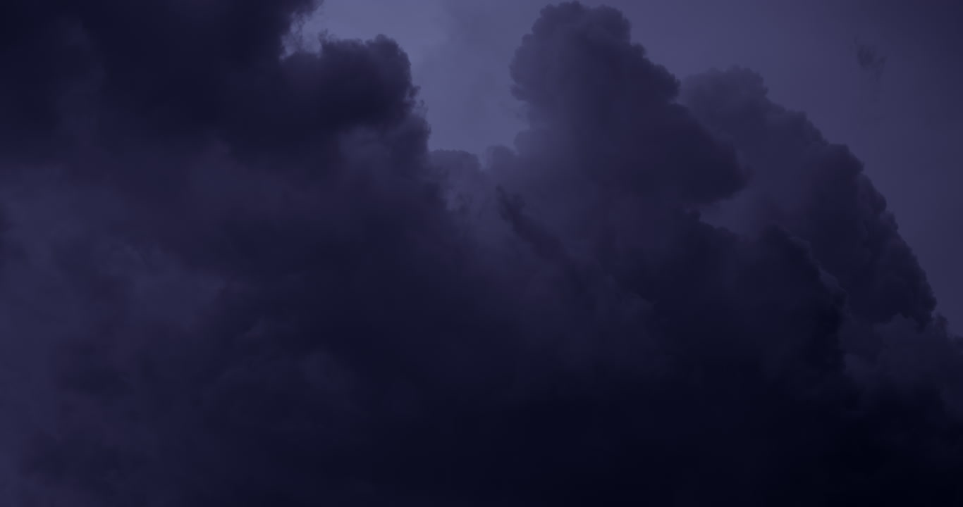 Dark storm clouds build upward at night, 4K