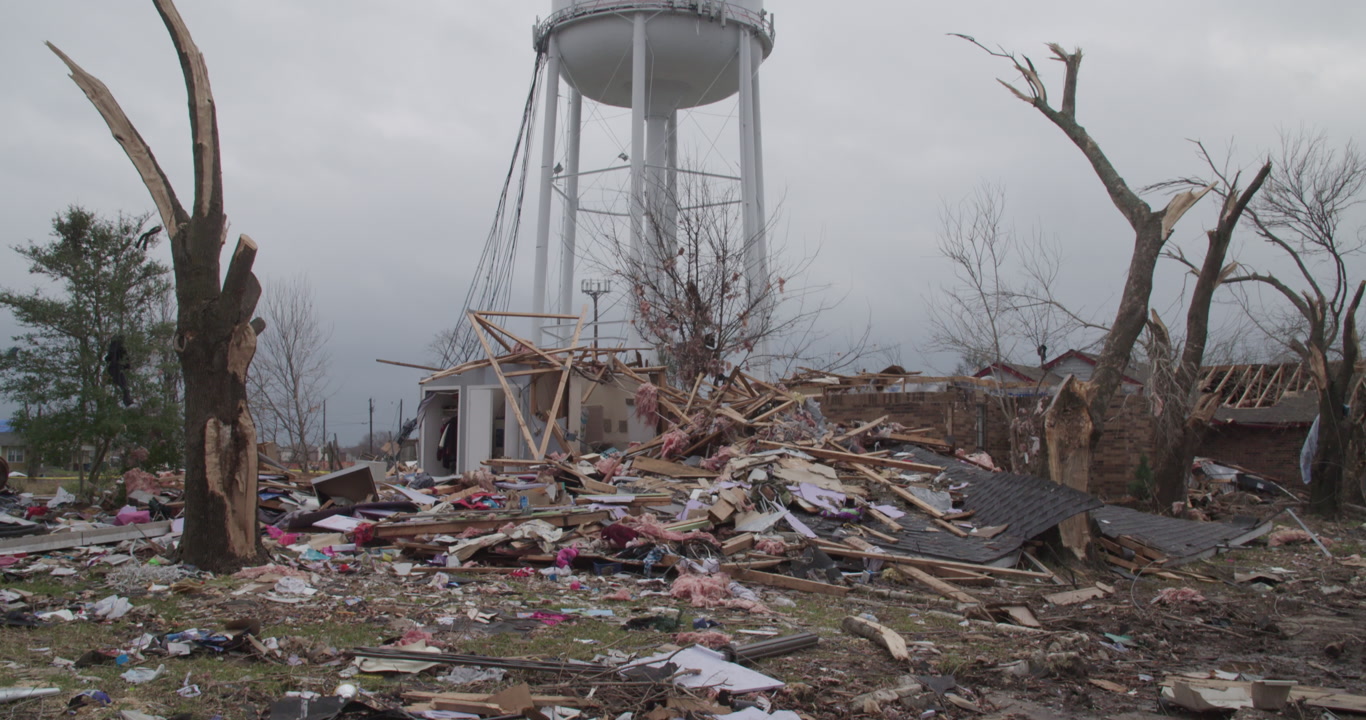 Tornado damage and aftermath - Tilt up over debris to reveal Rowlett, Texas water tower, 4K