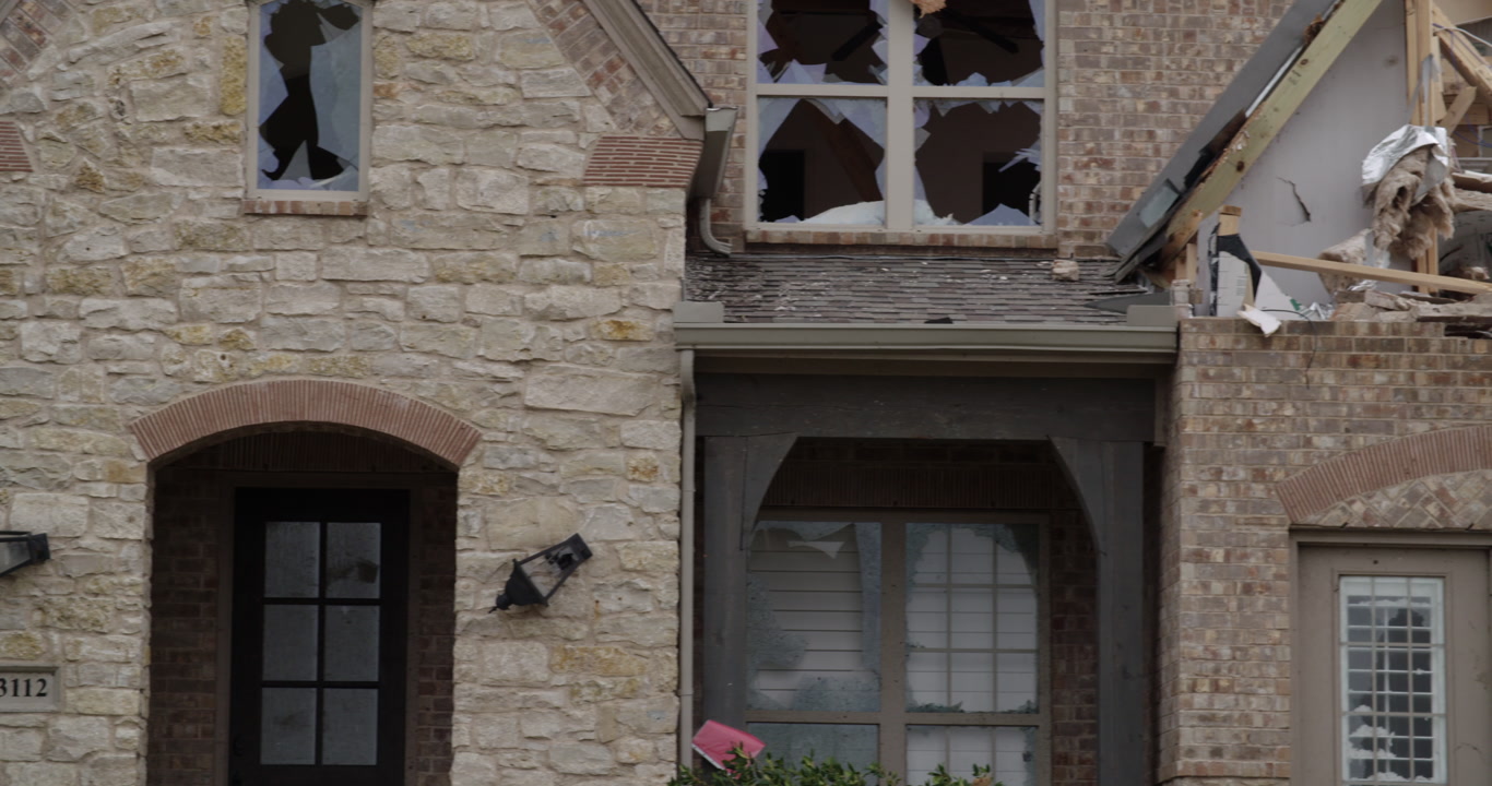 Tornado damage and aftermath - pan left, damaged brick and stone house, 4K