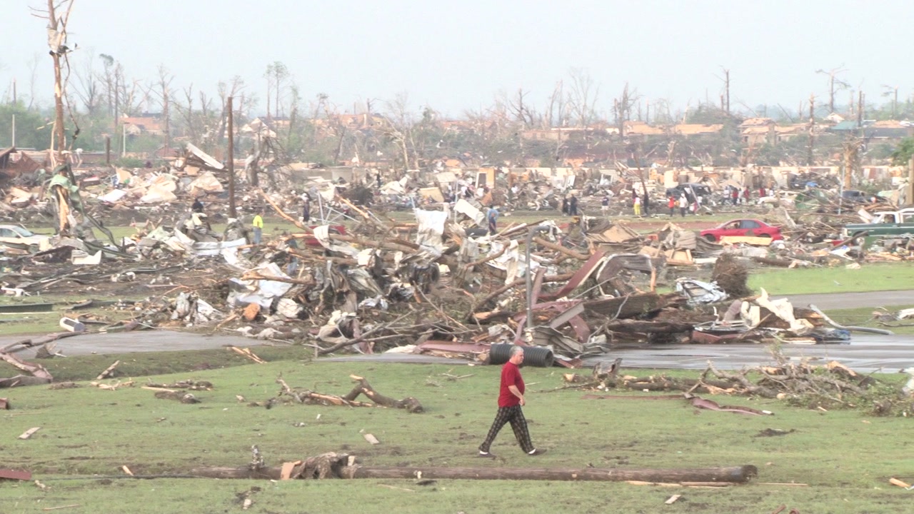 Tornado damage and aftermath - man in pajama pants walks across destroyed neighborhood
