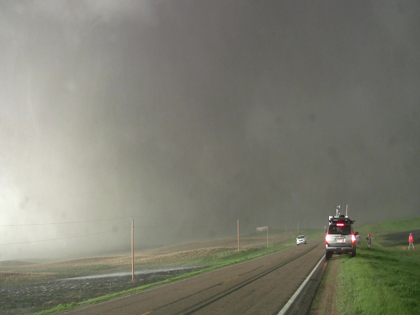 Tornado - massive tornado crosses highway, storm chaser parked right side