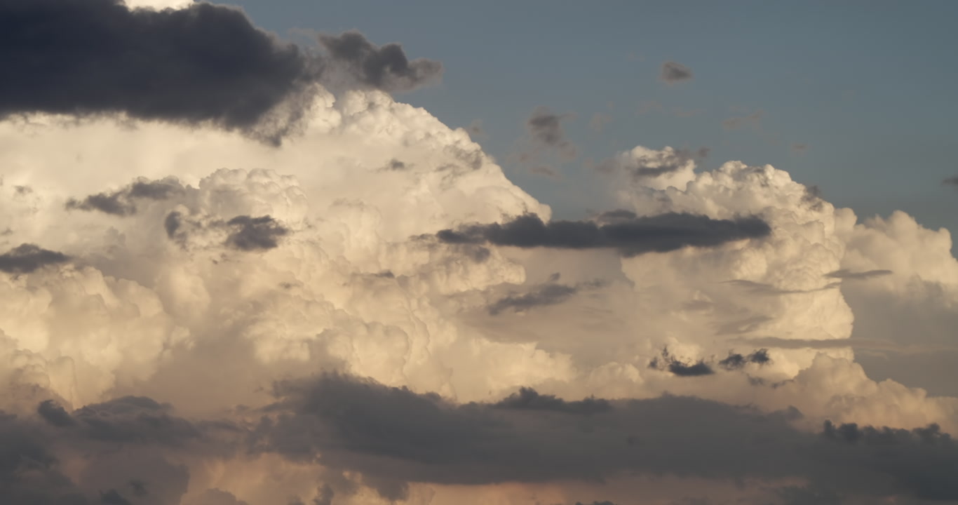 Close-up of thunderstorms developing in late day sunlight, time-lapse, 4K