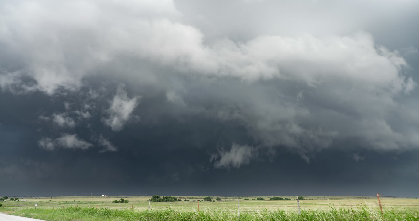 Severe thunderstorm approaches over green prairie, afternoon, 4K