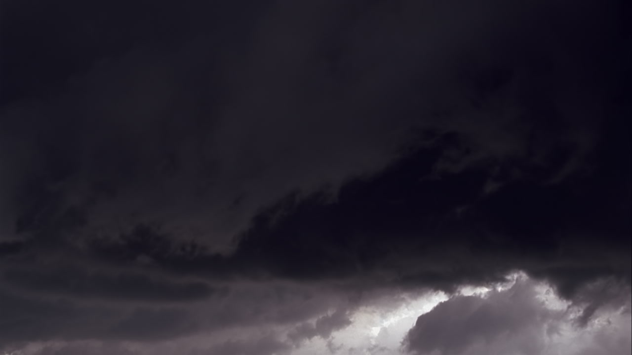 Dark gray storm clouds filled with lightning at dusk - Super 35mm film to HD 1080