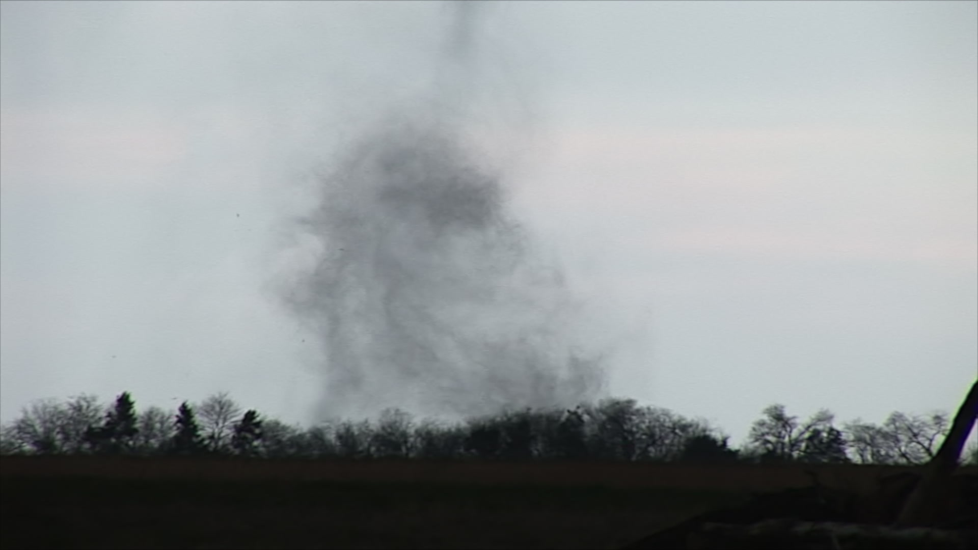 Small tornado tracks behind trees, HD