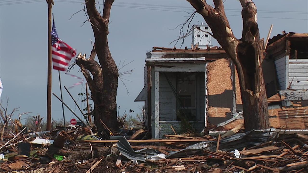 Zoom out, flags and damaged home - EF5 tornado aftermath damage, HD 1080