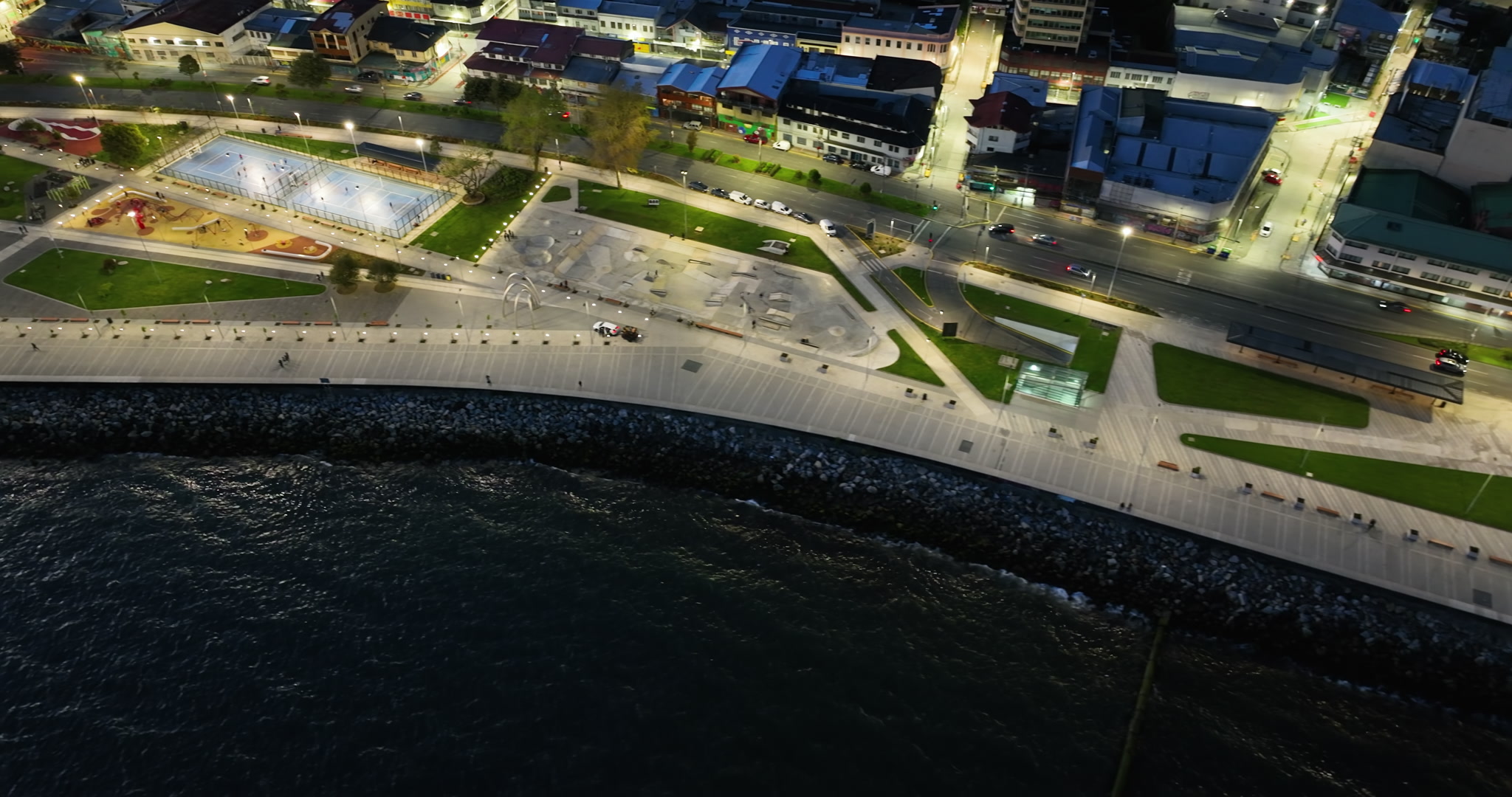 Tracking Right Aerial Over Illuminated Coastal Plaza