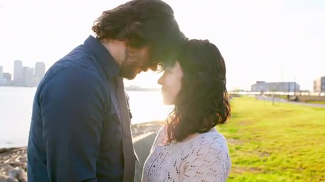 Couple embrace in a park near a bay