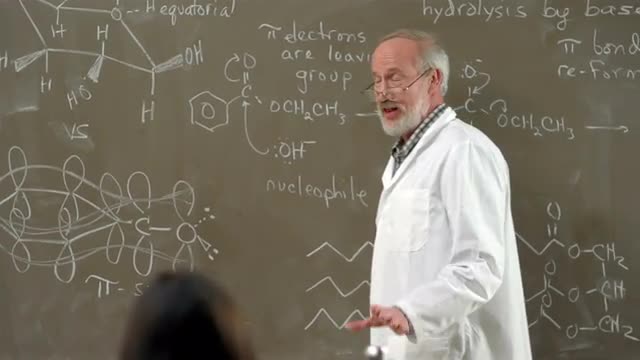 A university chemistry professor gives a lecture to his class