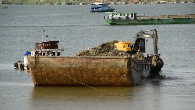 Excavator on Barge Fills Dirt into Cambodian River - Phnom Penh Cambodia