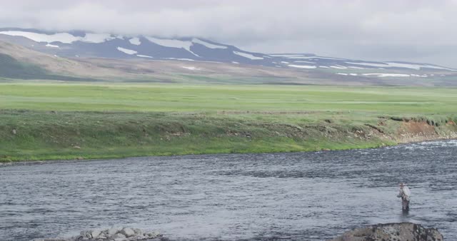 Fly fisherman in vast landscape