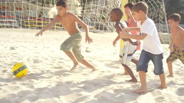 Kids playing soccer on a beach in Brazil 