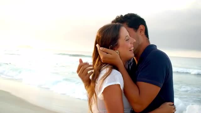 Brazilian couple embrace on a beach in Brazil